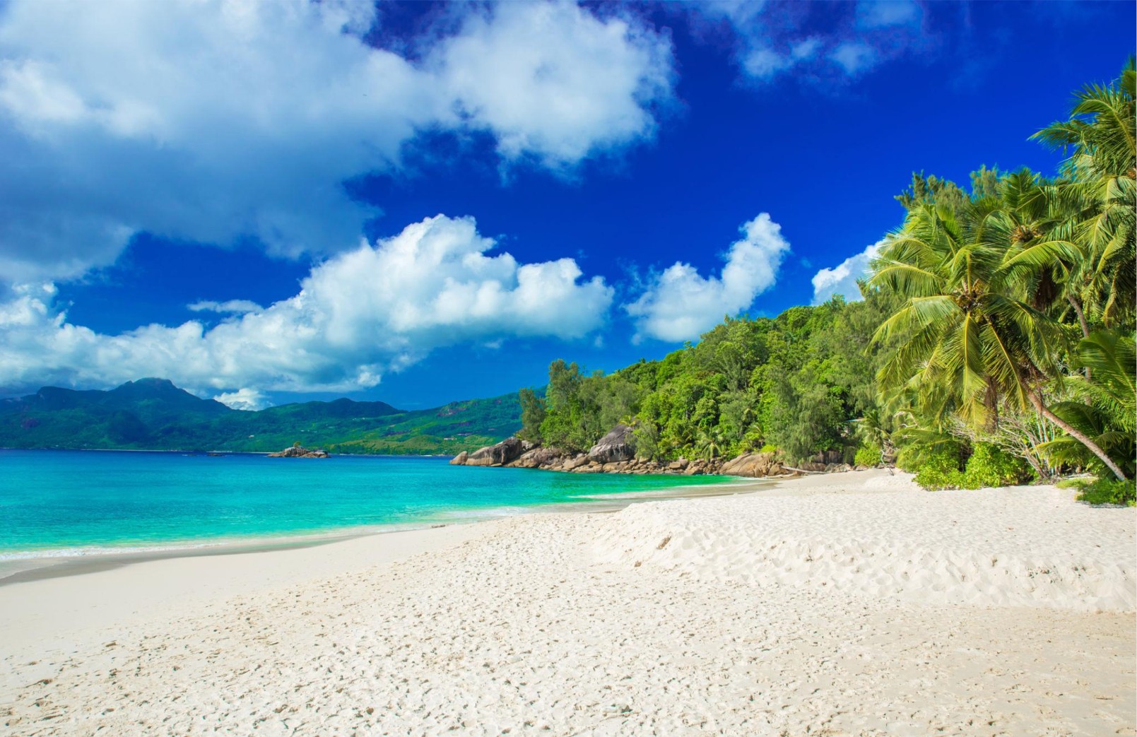Tropical beach with turquoise water and green mountains